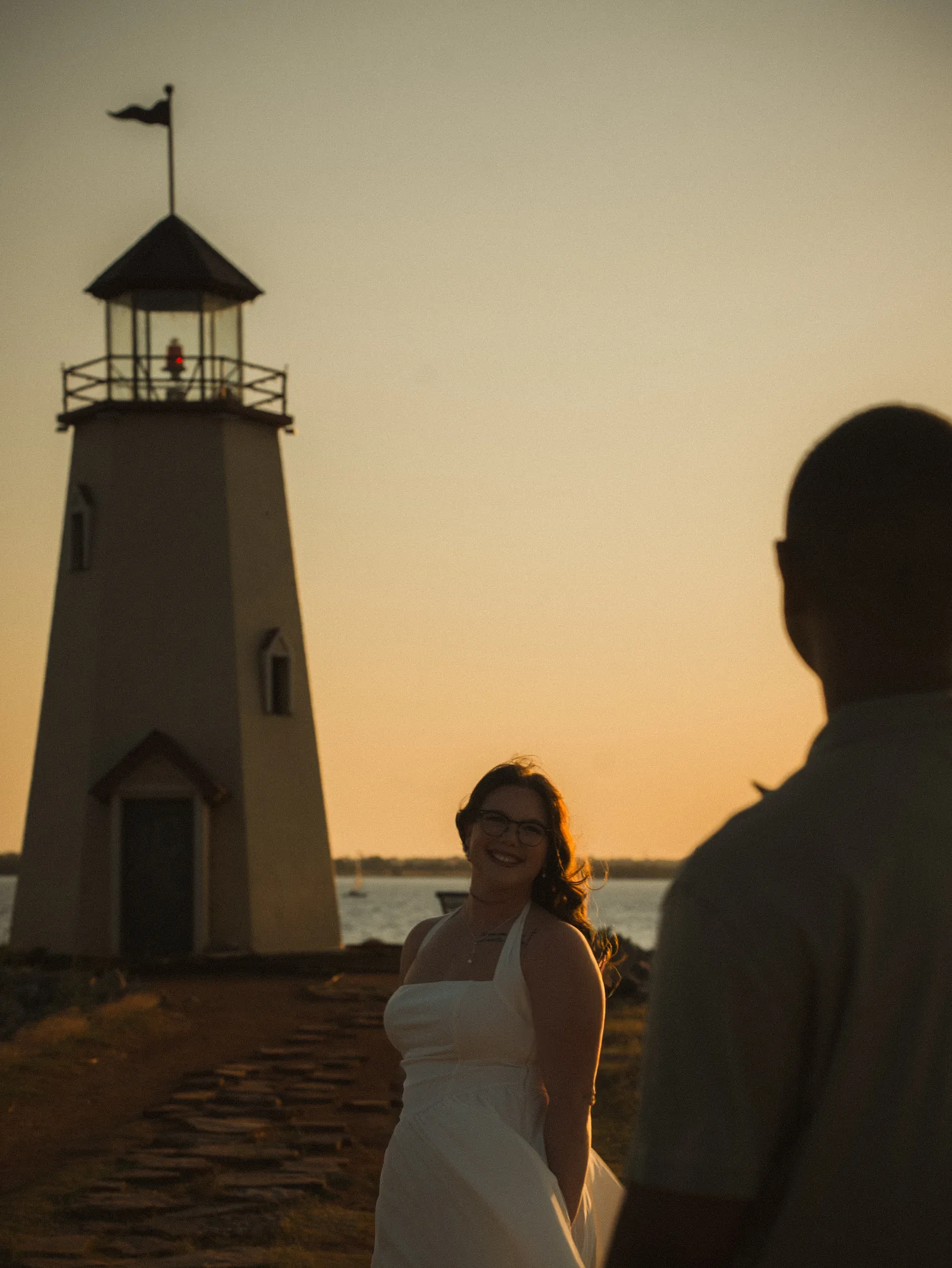 Couple at a lighthouse at golden hour, photographed by HardeeImagery in Oklahoma