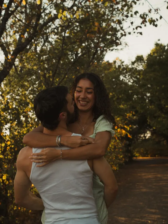 Couple hugging and smiling among the trees