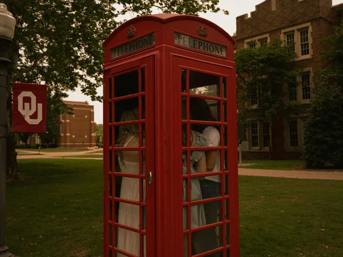 Friends inside a red phone booth on the University of Oklahoma campus