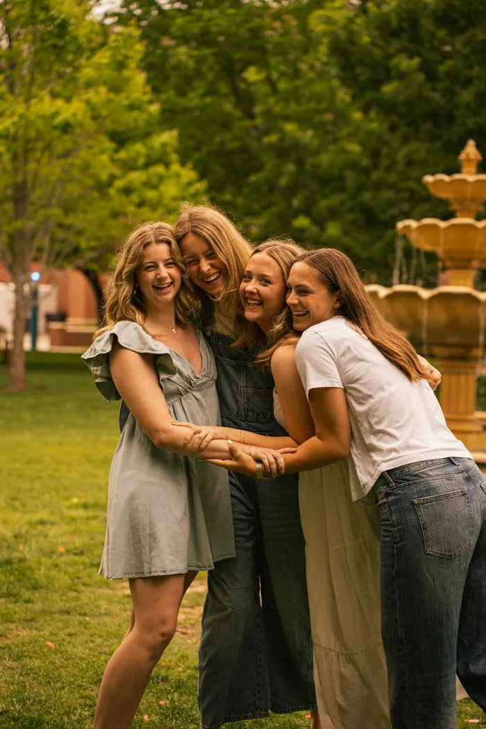 Group of friends laughing together by a fountain